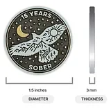 Photo of a circular sobriety coin with a soaring hawk design, moon, sun, mountains, and text reading "15 YEARS" and "SOBER," shown with size measurements of ...