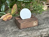 Photo of white sobriety coin displayed on wooden stand with engraved number ten